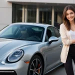 Young woman smiling next to a silver Porsche highlighting the Porsche steering wheel emphasizing advanced design and technology in 2024 options